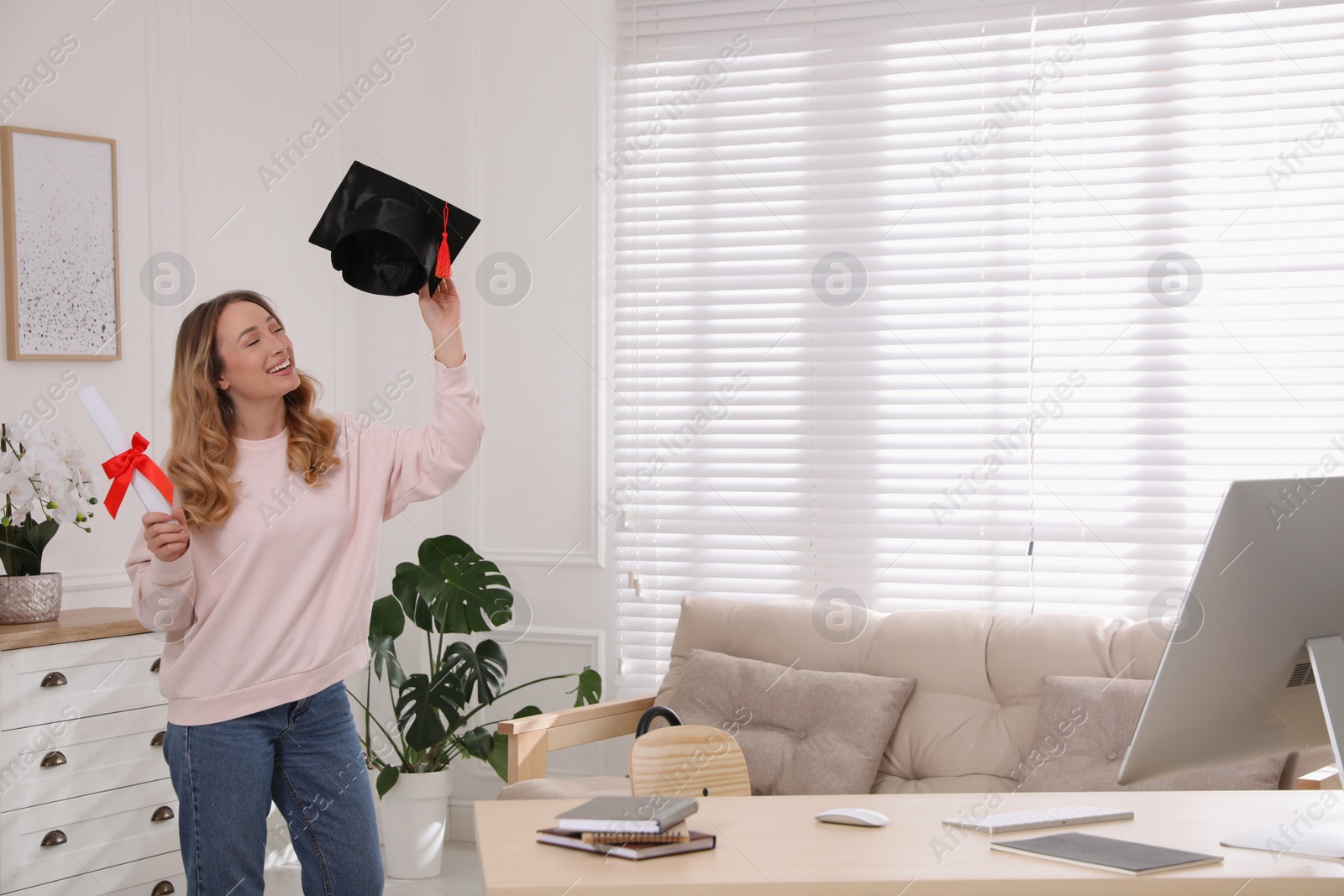 Photo of Happy student with graduation hat and diploma at workplace in office