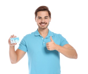 Happy young man with driving license on white background