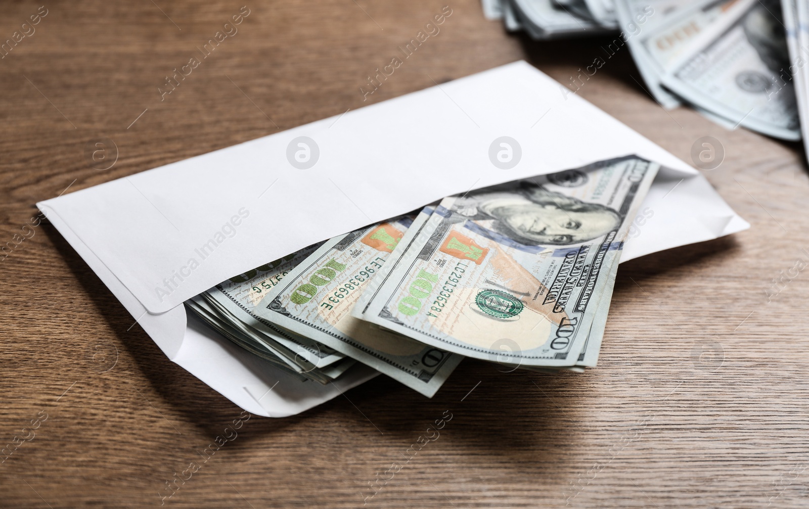 Photo of Envelope with dollar bills on wooden table. Bribe concept