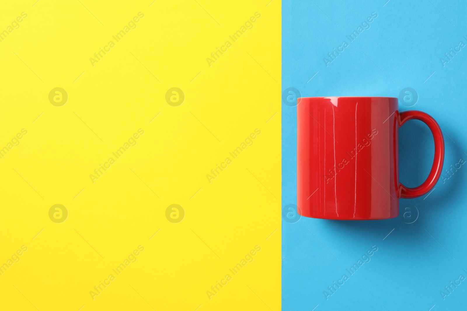 One red ceramic mug on color background, top view. Space for text Photo of One red ceramic mug on color background, top view. Space for text