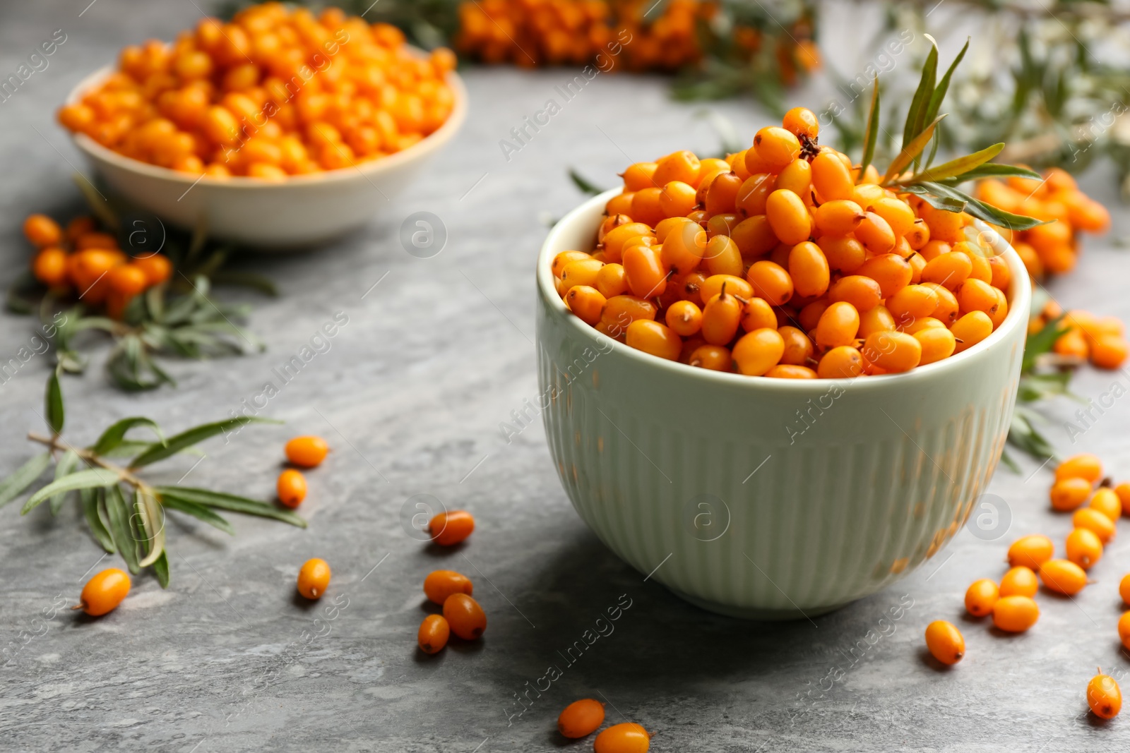 Photo of Fresh ripe sea buckthorn in bowl on grey table