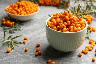 Fresh ripe sea buckthorn in bowl on grey table