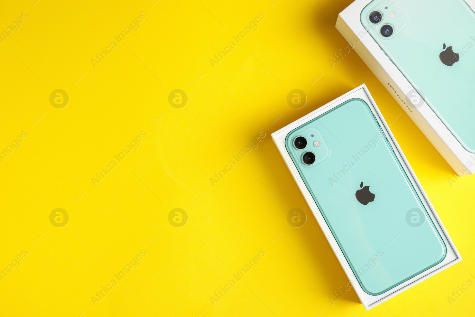 Photo of MYKOLAIV, UKRAINE - JULY 10, 2020: New modern Iphone 11 Green in original box on yellow background, flat lay. Space for text