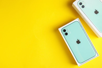 Photo of MYKOLAIV, UKRAINE - JULY 10, 2020: New modern Iphone 11 Green in original box on yellow background, flat lay. Space for text