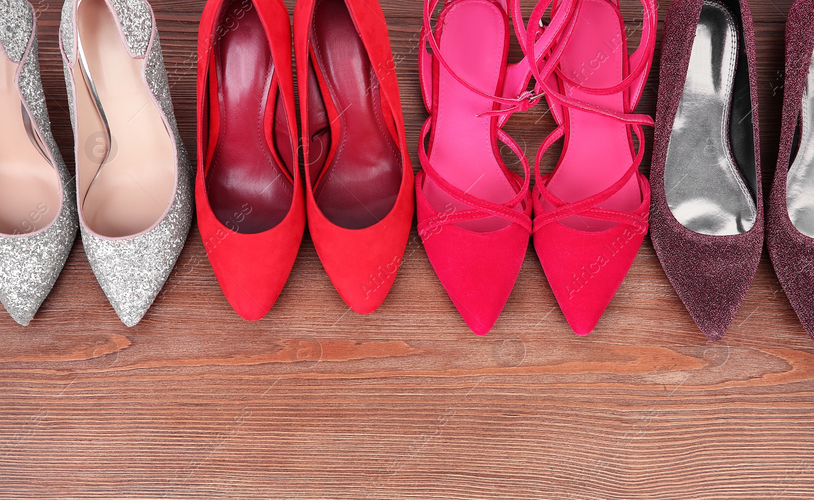 Photo of Different female shoes on wooden background