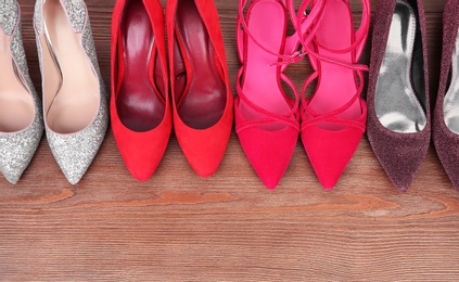 Photo of Different female shoes on wooden background