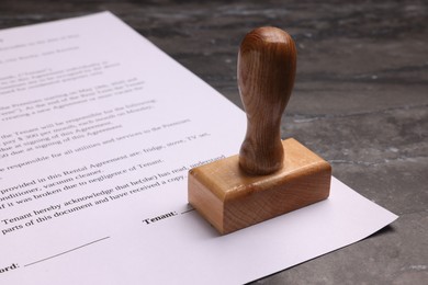Photo of One stamp tool and document on dark marble table, closeup