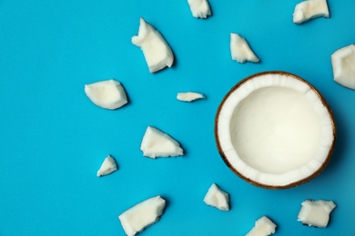 Fresh coconut pieces on blue background, flat lay