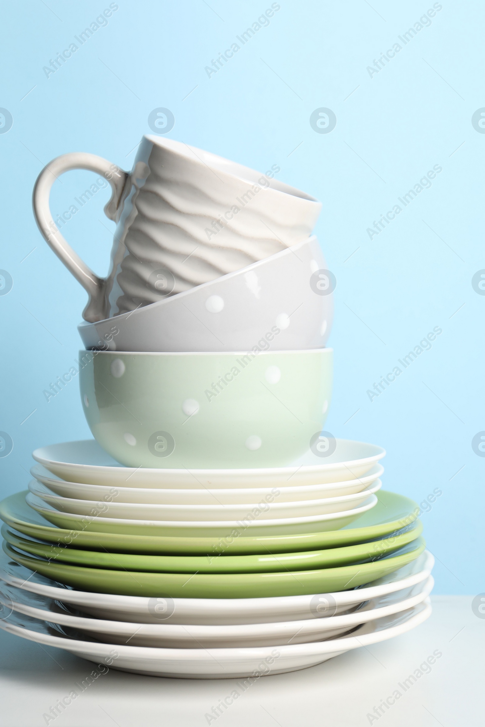 Photo of Beautiful ceramic dishware and cup on white table