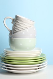 Beautiful ceramic dishware and cup on white table