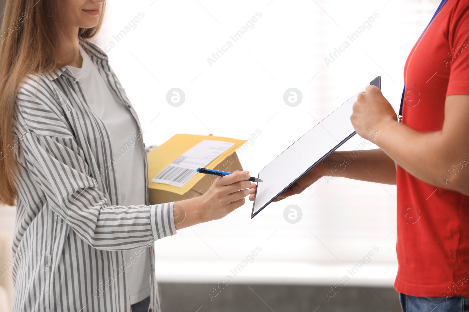 Photo of Woman signing for delivered parcels at home, closeup