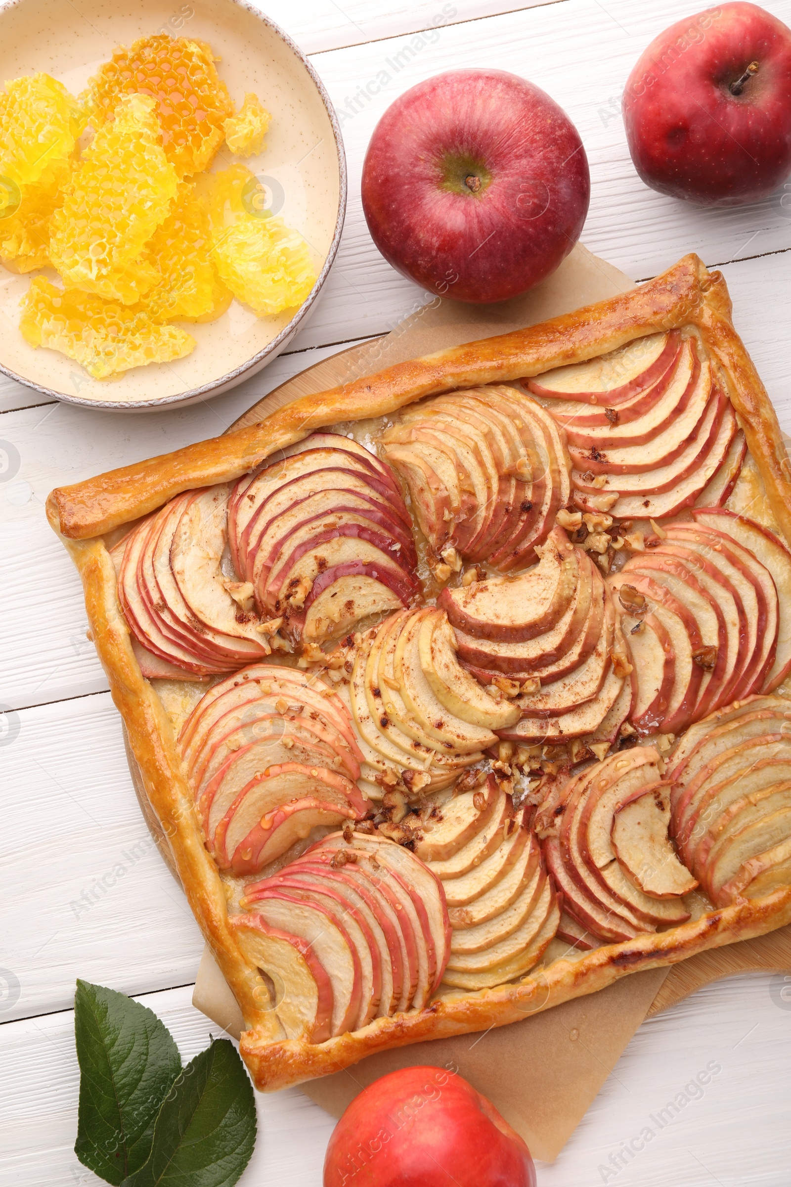 Photo of Tasty fresh apple galette and ingredients on white wooden table, flat lay