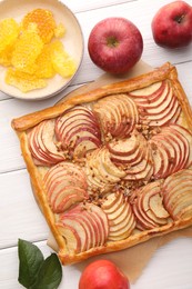 Photo of Tasty fresh apple galette and ingredients on white wooden table, flat lay