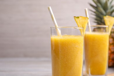 Tasty pineapple smoothie on table, closeup. Space for text