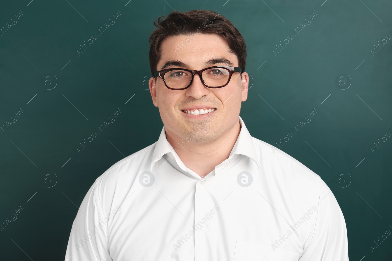 Photo of Portrait of male teacher near chalkboard