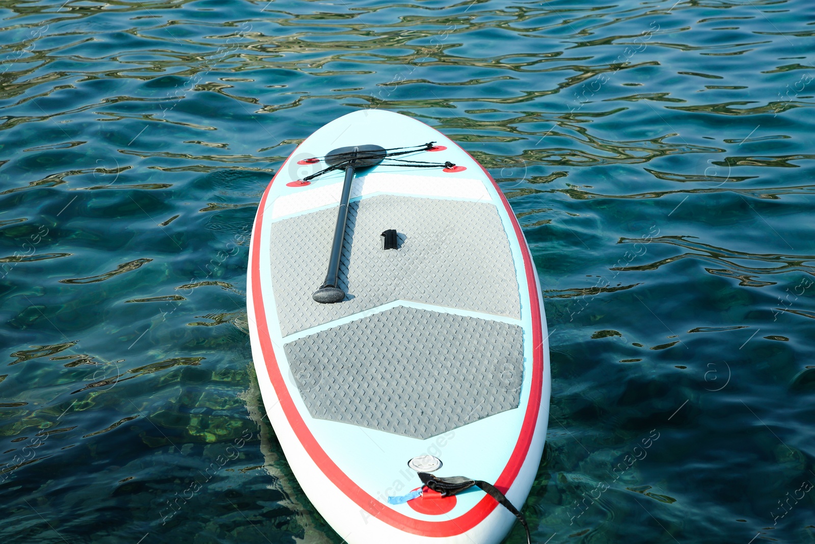 Photo of One SUP board with paddle on sea water