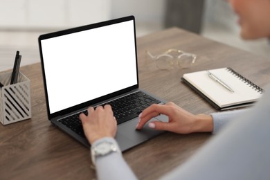 Photo of Young woman watching webinar at table indoors, closeup