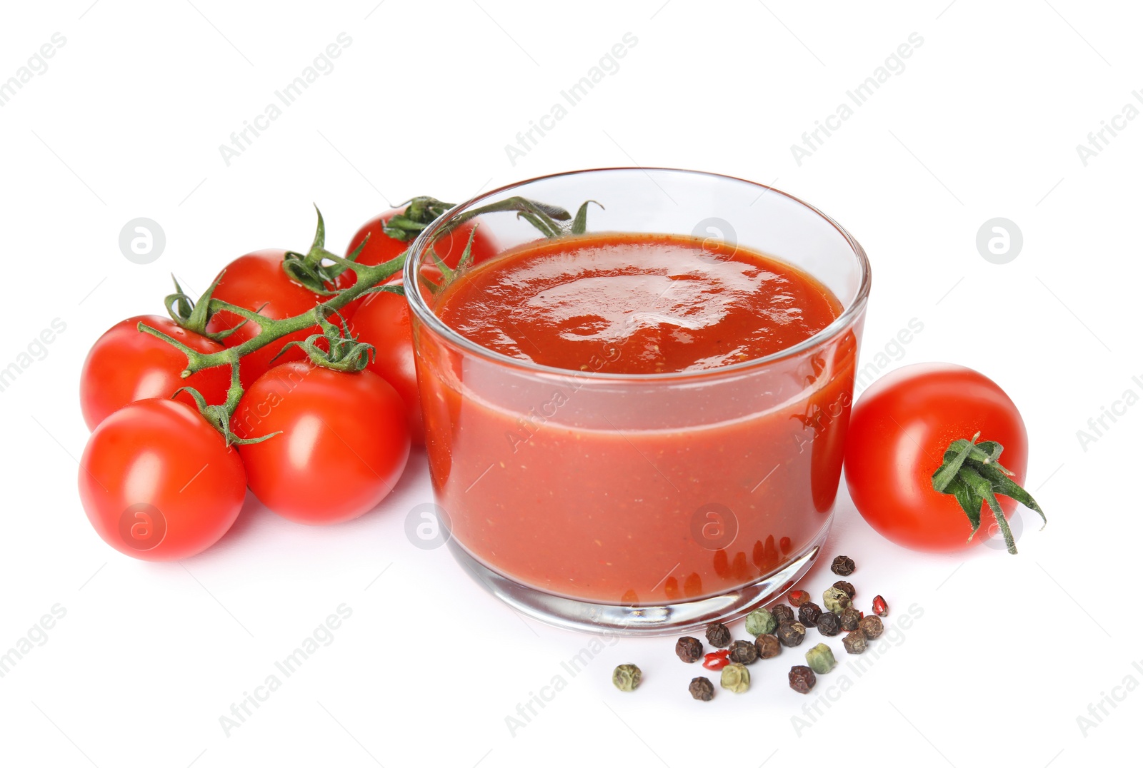 Photo of Glass of sauce, tomatoes and pepper isolated on white