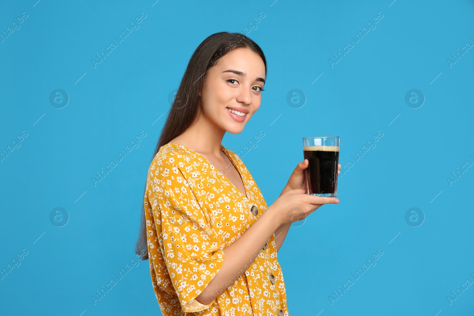 Photo of Beautiful woman with cold kvass on blue background. Traditional Russian summer drink