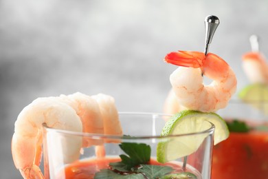 Photo of Tasty shrimp cocktail with sauce in glass on blurred background, closeup