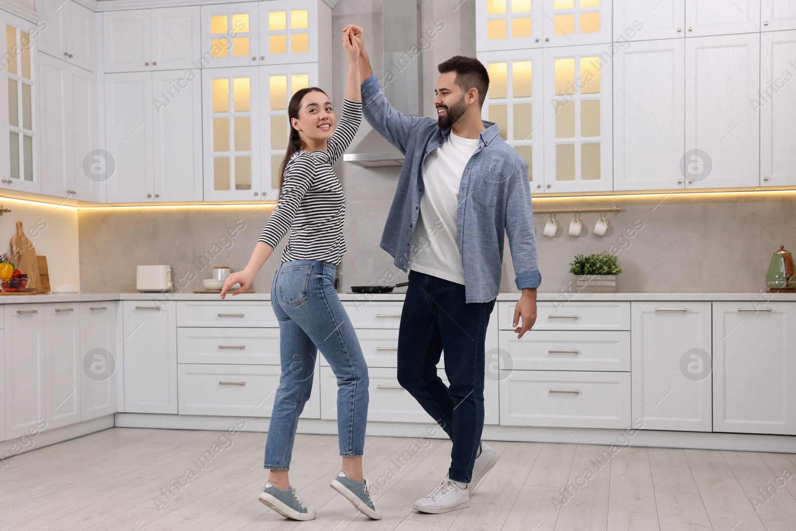 Photo of Happy lovely couple dancing together in kitchen