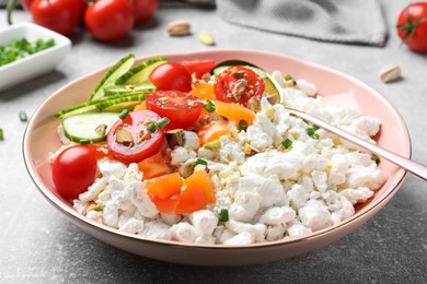 Photo of Delicious cottage cheese with vegetables served for breakfast on light grey table, closeup