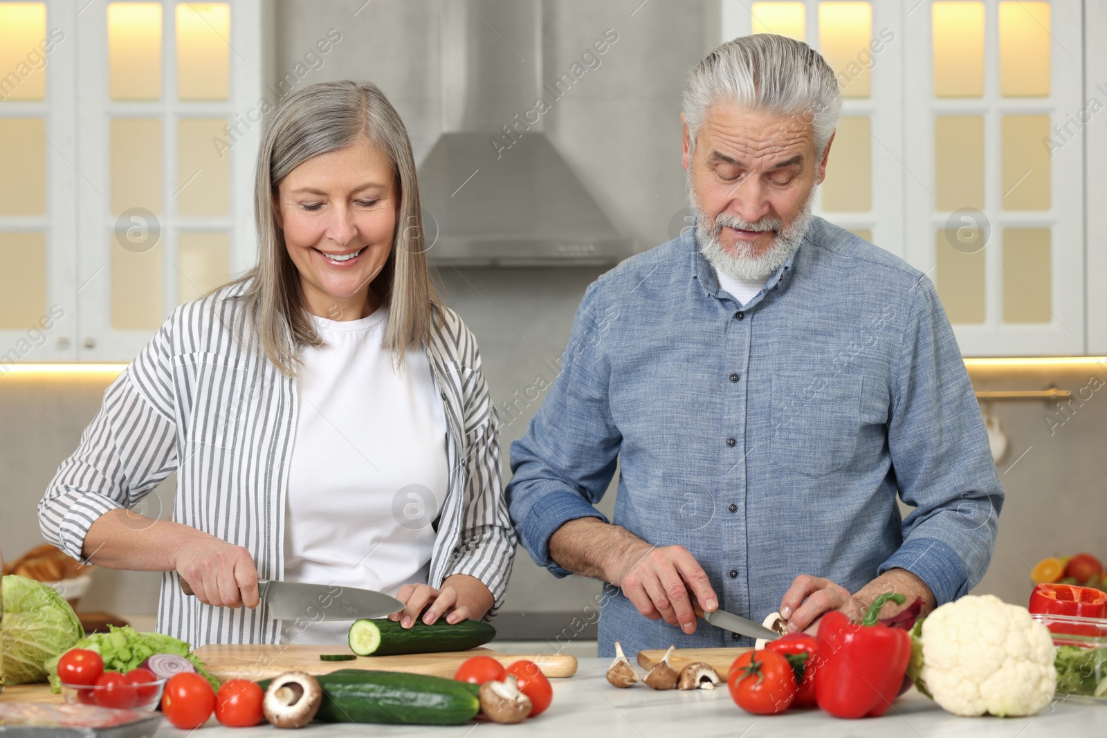 Photo of Happy senior couple cooking together in kitchen