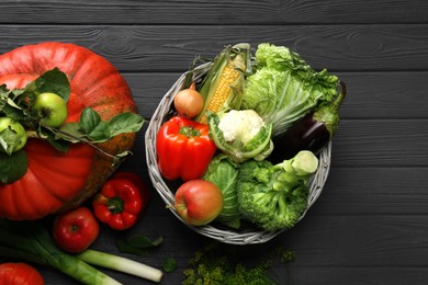 Different fresh vegetables and fruits on black wooden table, flat lay. Farmer harvesting