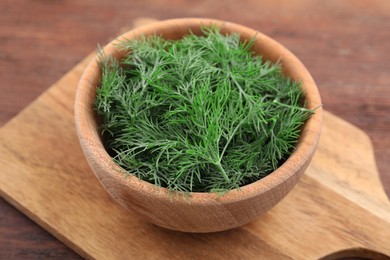 Bowl of fresh dill on wooden table