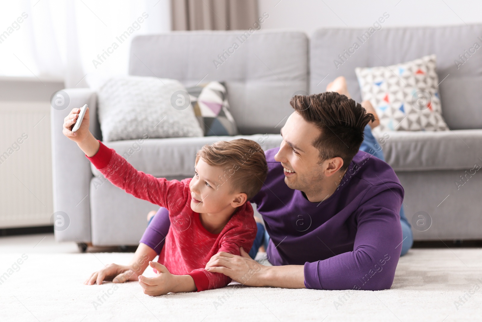 Photo of Dad and his son taking selfie at home