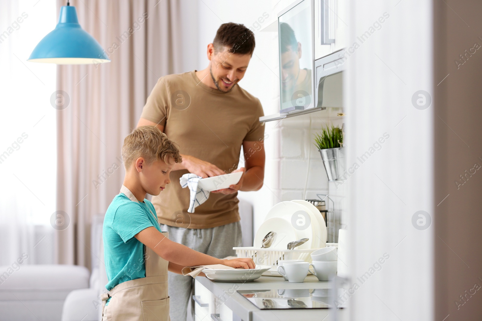 Photo of Dad and son wiping dishes in kitchen