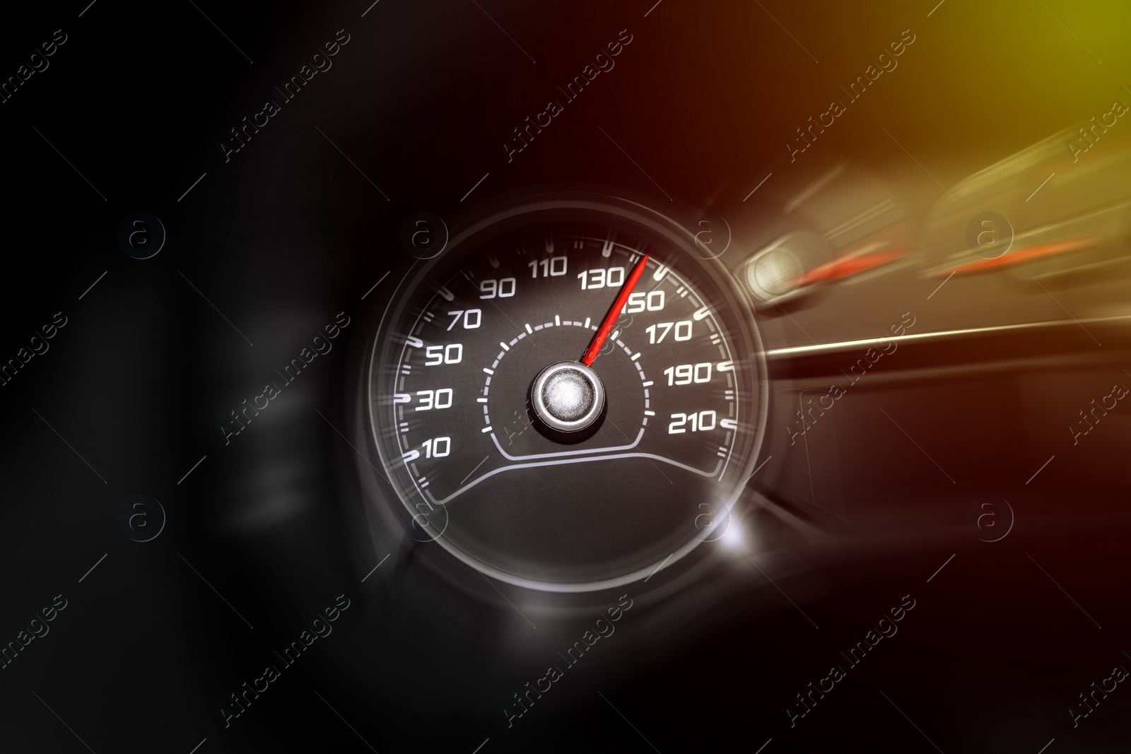 Image of Speedometer on car dashboard under yellow light, closeup. Motion blur effect