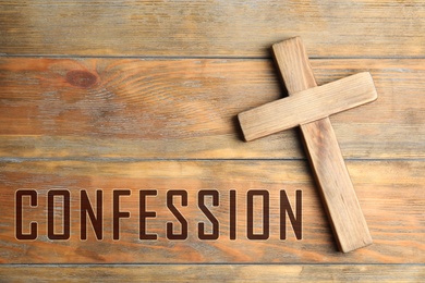 Image of Christian cross and word Confession on wooden background, top view