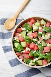 Photo of Delicious salad with watermelon, cucumber, arugula and feta cheese on white wooden table, flat lay