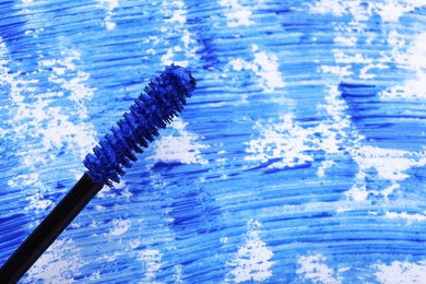 Photo of Applicator brush with blue mascara, closeup. Space for text
