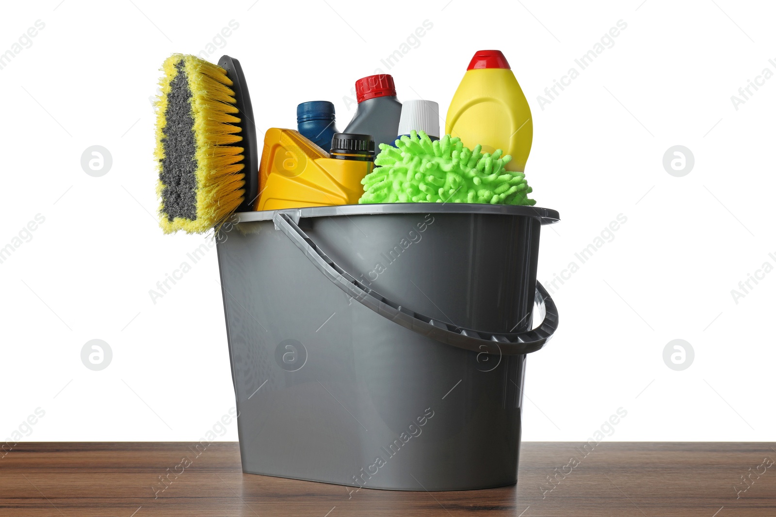 Photo of Grey bucket with car care products on wooden table against white background