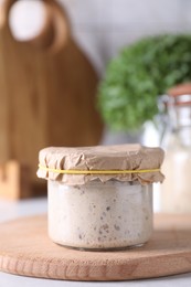 Photo of Sourdough starter in glass jar on table