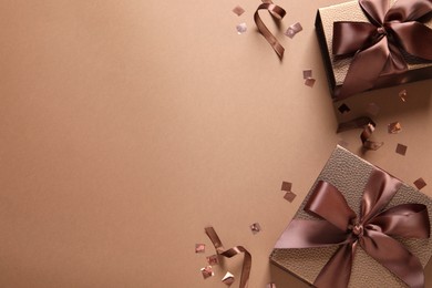 Photo of Beautiful gift boxes and confetti on brown background, flat lay. Space for text