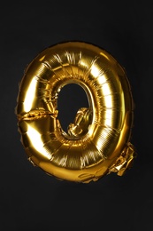 Photo of Golden letter Q balloon on black background