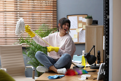 Photo of Lazy woman having fun while cleaning at home