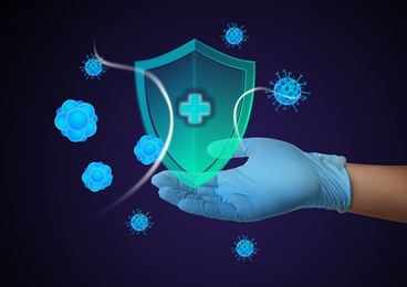 Image of Immunologist and shield with cross as symbol of virus protection on blue background, closeup