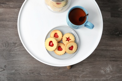 Photo of Traditional Christmas Linzer cookies with sweet jam on table, top view