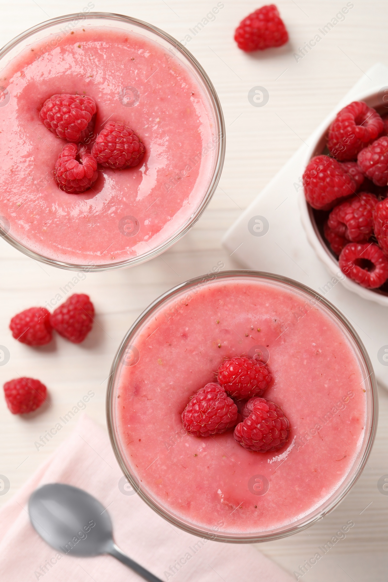 Photo of Delicious raspberry mousse on white wooden table, flat lay