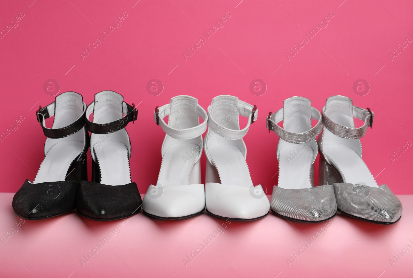 Photo of Many stylish female shoes on pink background