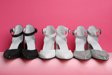 Photo of Many stylish female shoes on pink background