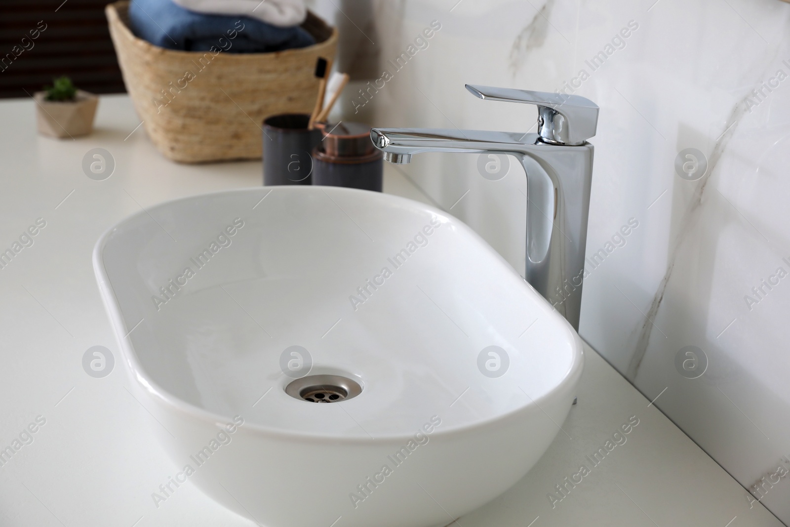 Photo of Stylish vessel sink on bathroom counter. Interior design