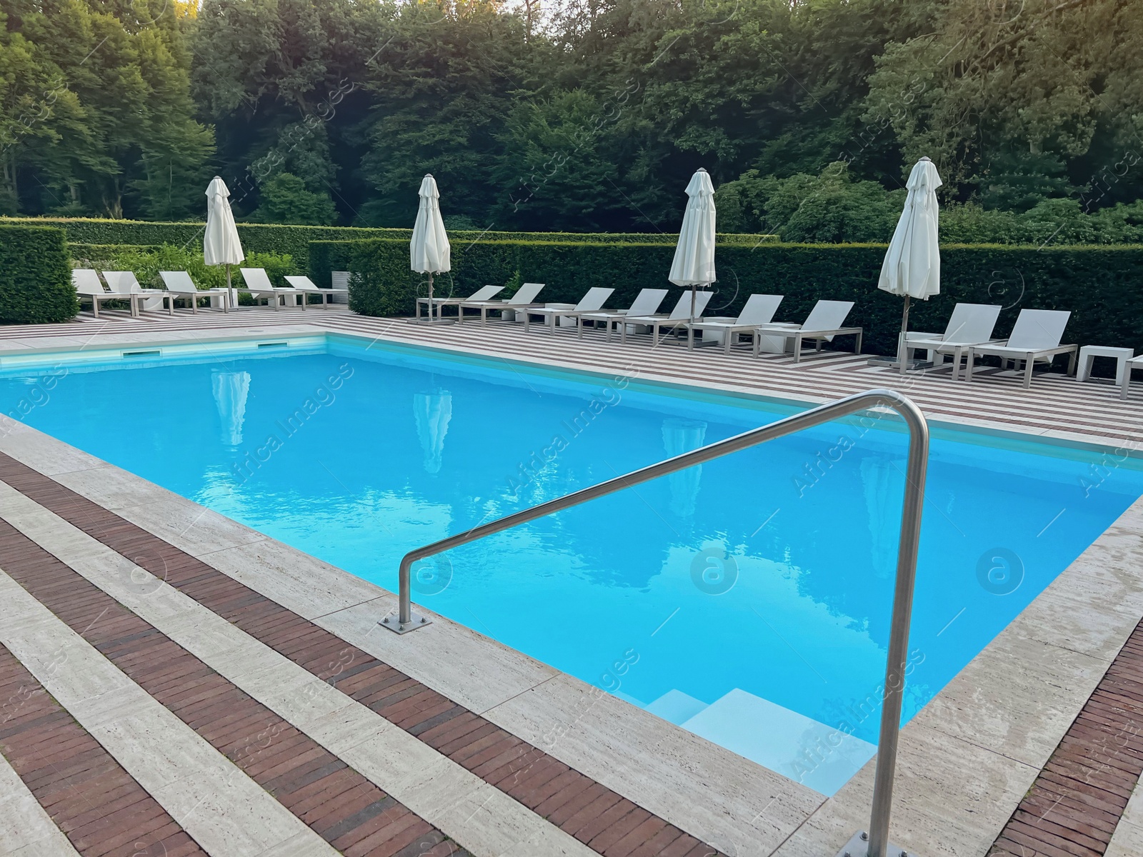 Photo of Outdoor swimming pool in luxury hotel on sunny summer day. Time for relax