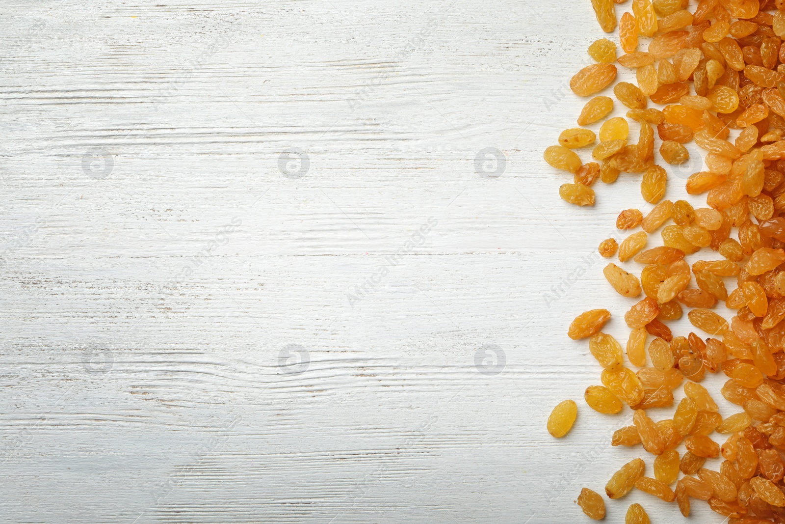 Photo of Raisins on wooden background, top view with space for text. Dried fruit as healthy snack