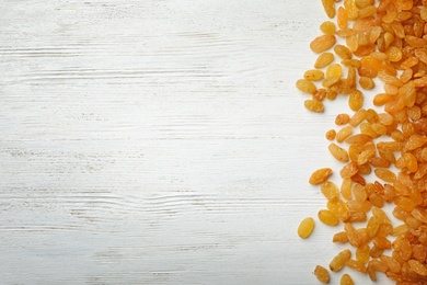 Raisins on wooden background, top view with space for text. Dried fruit as healthy snack