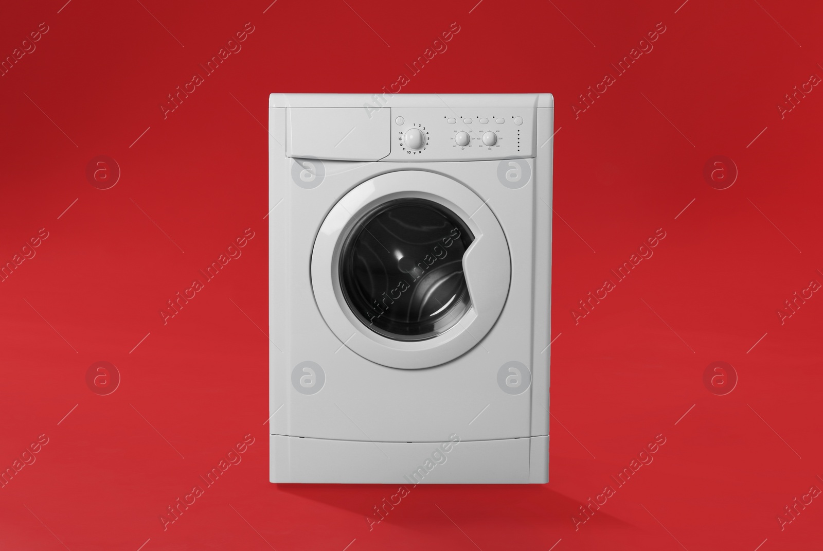 Photo of Modern washing machine on red background. Laundry day